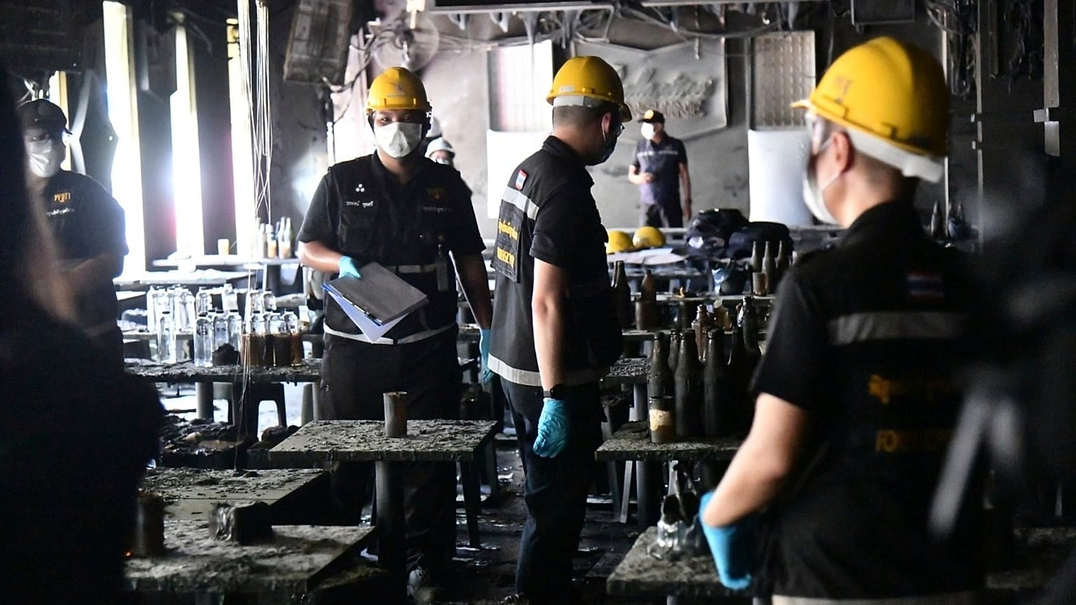 Forensic police officers inspect the site of a fire in Bangkok, 13 July, 2026