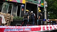 Forensic police officers inspect the site of a fire in Bangkok, 13 July, 2026