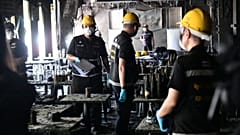 Forensic police officers inspect the site of a fire in Bangkok, 13 July, 2026