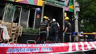 Forensic police officers inspect the site of a fire in Bangkok, 13 July, 2026