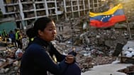 A woman sits amid the rubble of a building waiting to find her two children after the earthquakes in La Guaira, 12 July, 2026