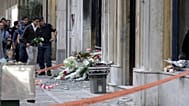 Ανδρας αφήνει λουλούδια στο υποκατάστημα της MARFIN στην Σταδίου μετά τη δολοφονική επίθεση στη διάρκεια πορείας το 2010