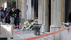 Ανδρας αφήνει λουλούδια στο υποκατάστημα της MARFIN στην Σταδίου μετά τη δολοφονική επίθεση στη διάρκεια πορείας το 2010