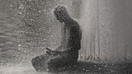 A person cools off at Trocadero fountain near the Eiffel Tower during a heat wave in Paris, 24 June, 2026