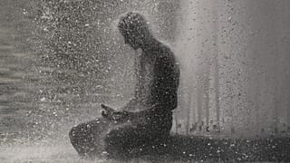 A person cools off at Trocadero fountain near the Eiffel Tower during a heat wave in Paris, 24 June, 2026