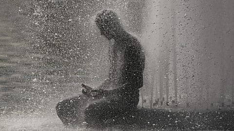 Eine Person verschafft sich Abkühlung am Trocadéro-Brunnen nahe dem Eiffelturm während einer Hitzewelle in Paris, 24. Juni 2026.
