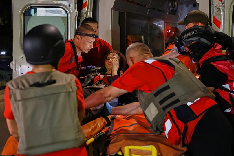 Rescuers evacuate a resident from an apartment building destroyed by a Russian drone attack on Zaporizhzhia, 12 July, 2026