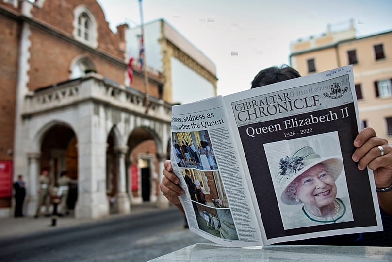 Una persona lee un periódico con la noticia del fallecimiento de la reina Isabel II en una cafetería frente al Palacio del Convento, el viernes 9 de septiembre de 2022.