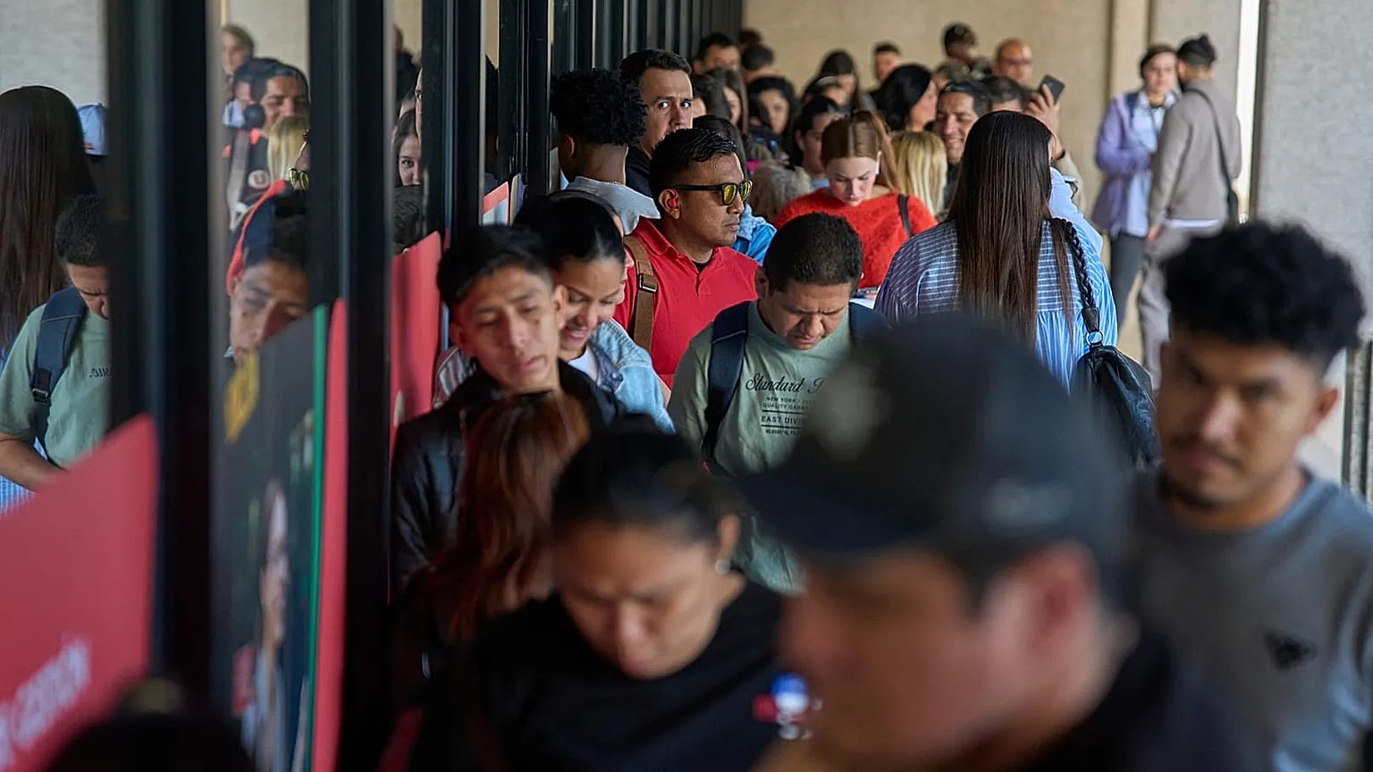 Inmigrantes hacen cola para solicitar el certificado de transporte público que les permitirá tramitar permisos de trabajo y residencia en Madrid, el jueves 16 de abril de 2026