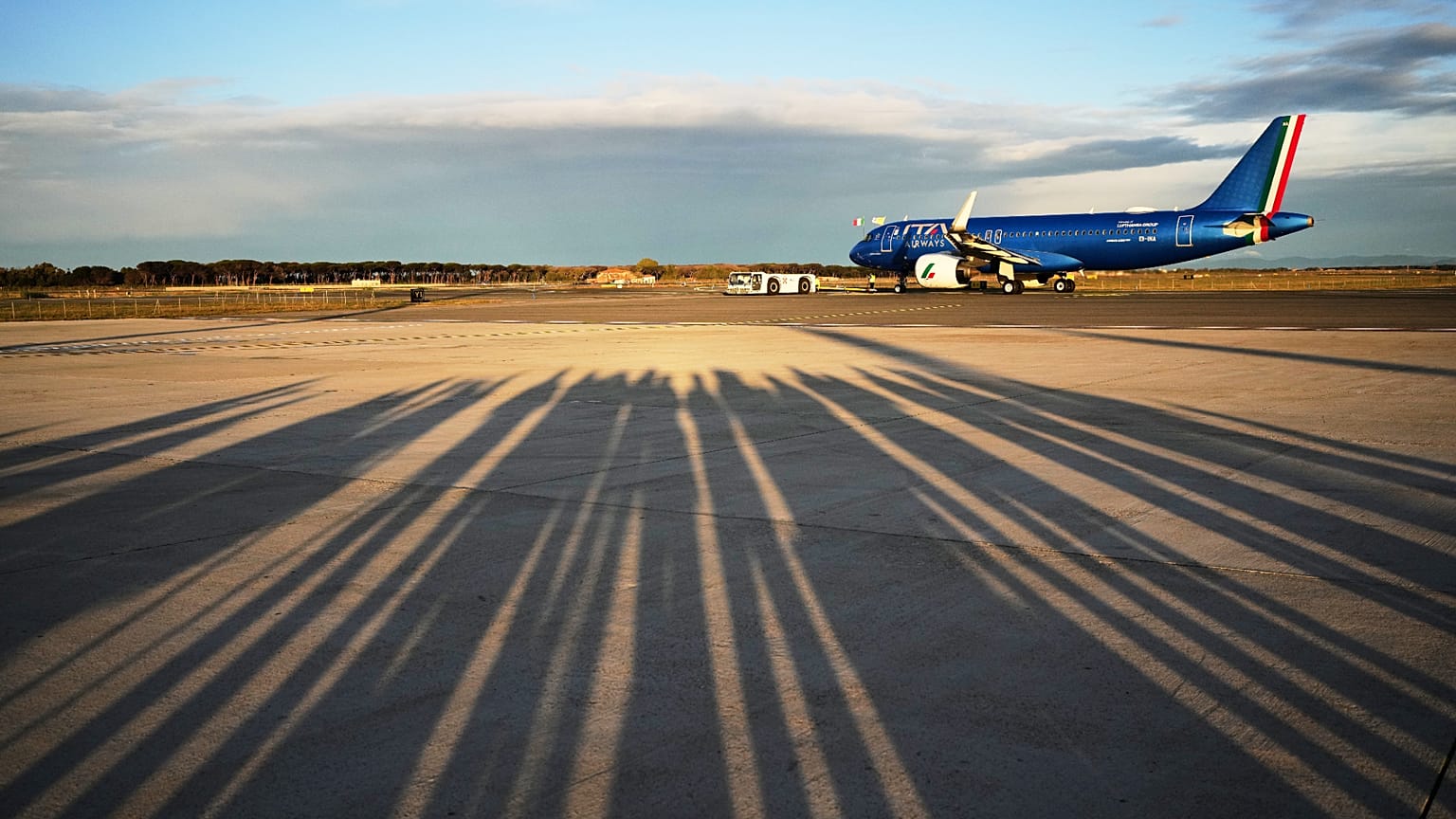 Reporters' shadows are cast on the tarmac as they wait for the plane to depart that is transporting Pope Leo XIV Fiumicino airport in Rome, Thursday, Nov. 27, 2025