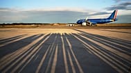 Reporters' shadows are cast on the tarmac as they wait for the plane to depart that is transporting Pope Leo XIV Fiumicino airport in Rome, Thursday, Nov. 27, 2025