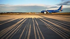 Reporters' shadows are cast on the tarmac as they wait for the plane to depart that is transporting Pope Leo XIV Fiumicino airport in Rome, Thursday, Nov. 27, 2025