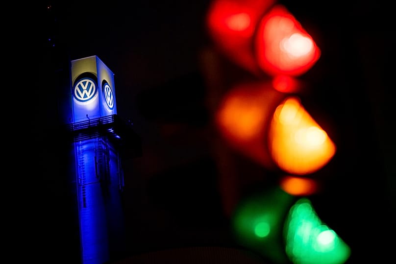 A traffic light shines in front of a Volkswagen logo at the Volkswagen plant in Osnabrück, 29 October, 2024