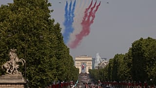 Des avions de la Patrouille de France, formation acrobatique, survolent le défilé militaire du 14 juillet sur les Champs-Élysées à Paris, mardi 14 juillet 2026.