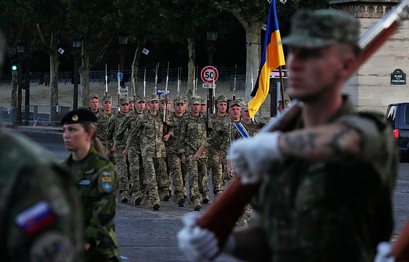 Des soldats ukrainiens défilent avec leur drapeau national lors d'une répétition du prochain défilé du 14 juillet, le jeudi 9 juillet 2026, sur les Champs-Élysées à Paris.