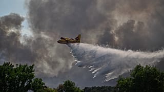 A Canadair water bomber drops water while fighting wildfires in the Fontainebleau forest region, 13 July, 2026