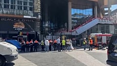 Des pompiers et des passants devant l'immeuble Oxy Tower, à Bruxelles (Belgique), le 14 juillet 2026.