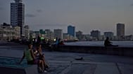 People hang out on the Malecon seawall at dusk during a blackout in Havana, Cuba, Tuesday, July 14, 2026 (AP Photo/Ramon Espinosa)