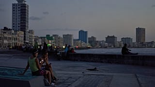 People hang out on the Malecon seawall at dusk during a blackout in Havana, Cuba, Tuesday, July 14, 2026 (AP Photo/Ramon Espinosa)