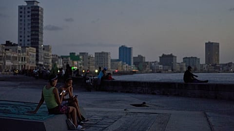 People hang out on the Malecon seawall at dusk during a blackout in Havana, Cuba, Tuesday, July 14, 2026 (AP Photo/Ramon Espinosa)