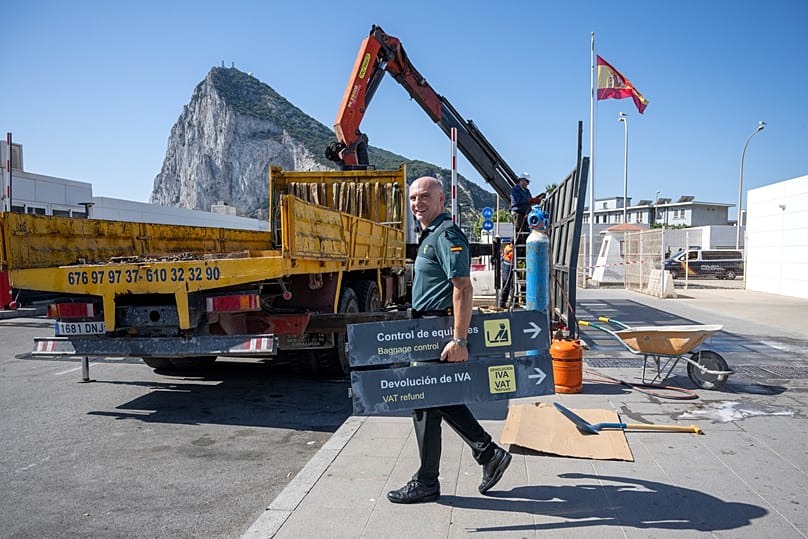 A Spanish Guardia Civil officer holds a sign during the dismantling of a border checkpoint in La Línea de la Concepción, 6 July, 2026
