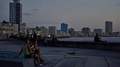 Küba'nın başkenti Havana'da elektrik kesintisi sırasında insanlar, gün batımında Malecon sahilinde /  14 Temmuz 2026 Salı