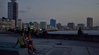 Küba'nın başkenti Havana'da elektrik kesintisi sırasında insanlar, gün batımında Malecon sahilinde /  14 Temmuz 2026 Salı