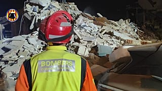 Un miembro de los bomberos de Valencia observa el derrumbe