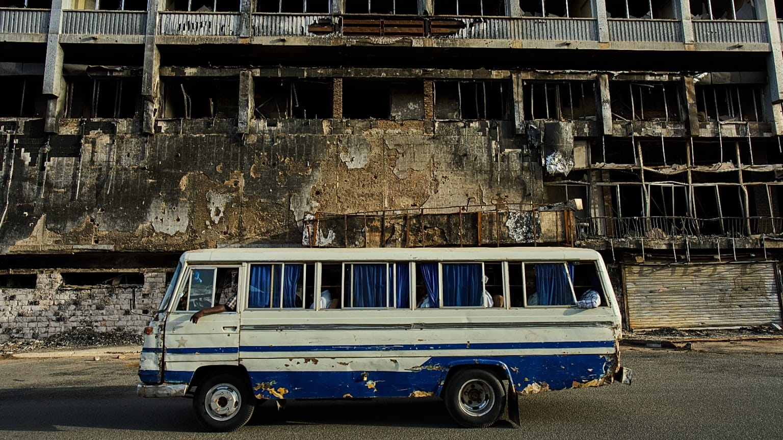 A bus drives past a hotel destroyed during the war in downtown Khartoum, 19 April, 2026
