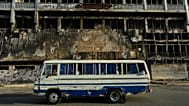 A bus drives past a hotel destroyed during the war in downtown Khartoum, 19 April, 2026