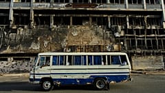 A bus drives past a hotel destroyed during the war in downtown Khartoum, 19 April, 2026