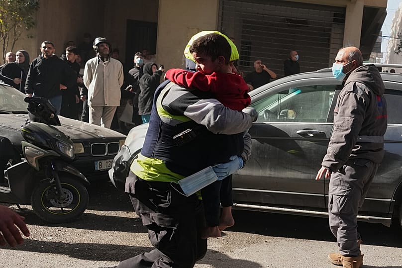 عامل إنقاذ يحمل طفلاً في موقع غارة جوية إسرائيلية وسط بيروت، لبنان، يوم الأربعاء 18 مارس/آذار 2026. 