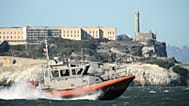 A US Coast Guard crew goes past Alcatraz Island near the site of a pontoon boat accident in San Francisco, 14 July, 2026