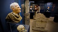 A látogatók római kori koponyákat és azok arcrekonstrukcióit nézik az Aquincumi Múzeum „Egyszer olyanok voltunk, mint ti” című kiállításán, amely szereplőket és a fictio