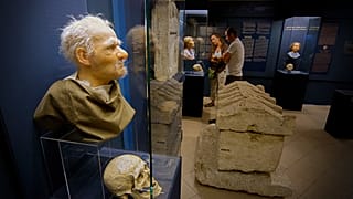 Visitantes observam crânios da época romana e suas reconstruções faciais na exposição do Museu Aquincum «Once we were like you», que apresenta personagens e ficção