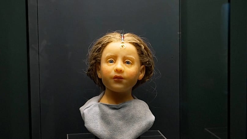 A reconstructed face of a Roman-era child, imagined as the member of a family of textile dyers, is displayed at Budapest’s Aquincum Museum.
