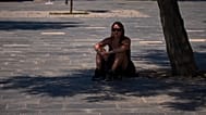 Una mujer se refugia bajo un árbol en las calles de Barcelona el pasado 27 de mayo