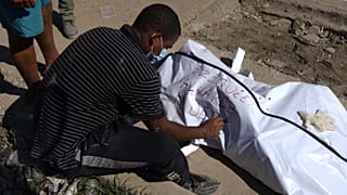 خوليو لاديرا يدوّن اسم ابن شقيقه بعد العثور على جثمانه بين أنقاض المباني التي دمرتها الزلازل في لا غوايرا، فنزويلا، في 7 يوليو 2026.
