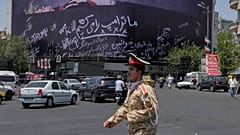 An army cadet walks past a billboard bearing anti-Trump messages, including the phrase "We Kill Trump," at Islamic Revolution Square in downtown Tehran, Iran, 15/07/2026.