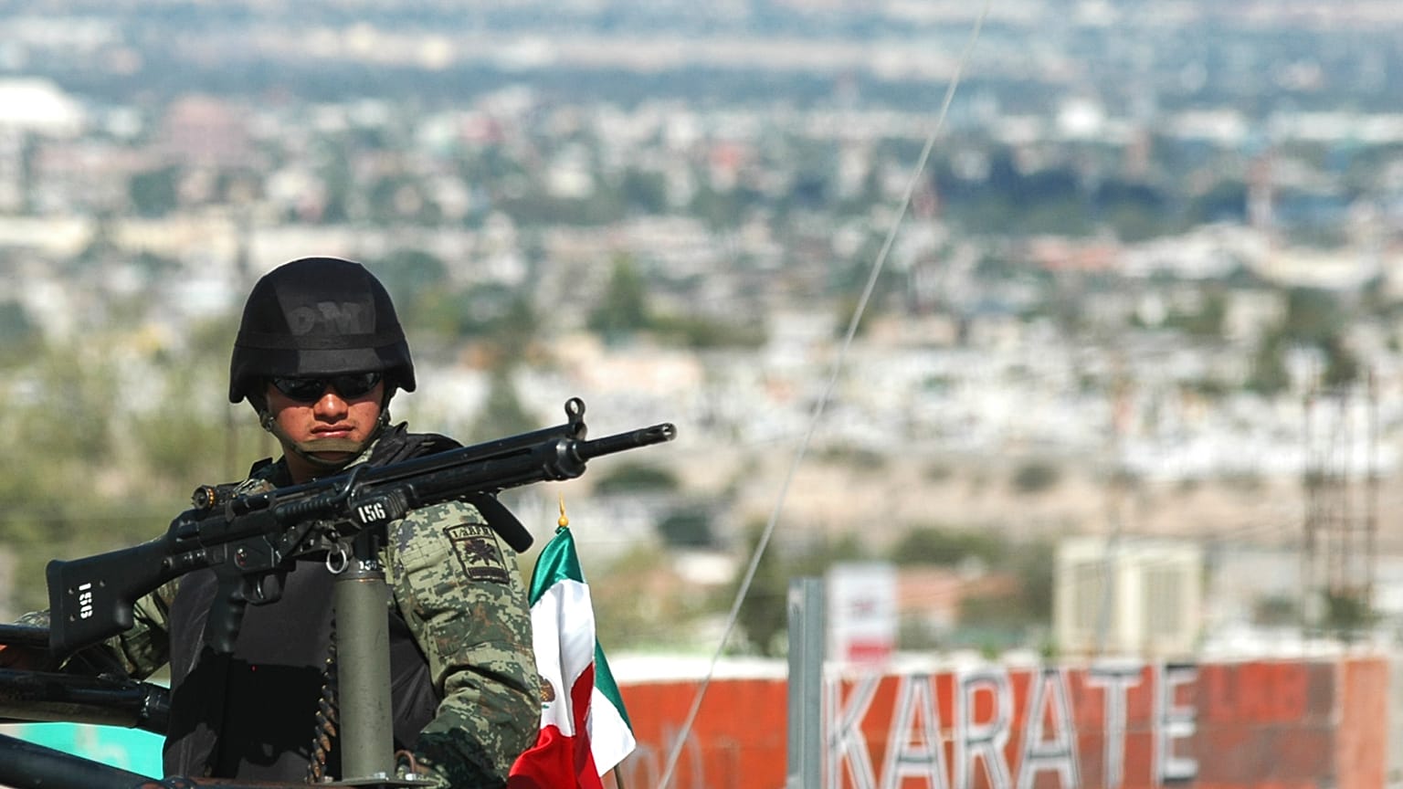 Un soldado custodia la escena de un crimen donde un hombre fue asesinado a tiros mientras conducía su automóvil en Ciudad Juárez, al norte de México, el 18 de septiembre 2009