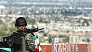 Un soldado custodia la escena de un crimen donde un hombre fue asesinado a tiros mientras conducía su automóvil en Ciudad Juárez, al norte de México, el 18 de septiembre 2009