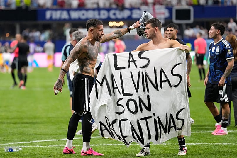 Argentina's Giovani Lo Celso holds a banner with the words "The Malvinas are Argentine", at the end of the World Cup semifinal match against England in Atlanta, July 15, 2026.