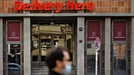 File - A man with a face mask stand in front of the entrance of the headquarters of the food delivery company 'Deleivery Hero' in Berlin, Germany, Wednesday, 28 Oct. 2020. 