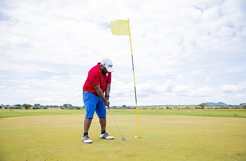Golfspieler auf einem Green, Tansania, Juli 2026