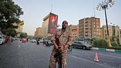 صورة تعبيرية- عنصر من قوات "الباسيج" شبه العسكرية الإيرانية يقف عند نقطة تفتيش قبيل مراسم جنازة المرشد الأعلى الراحل آية الله علي خامنئي