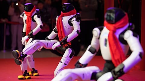 Humanoid robots dance in formation during a Lunar New Year tech temple fair performance in Beijing, Thursday, Feb. 19, 2026.
