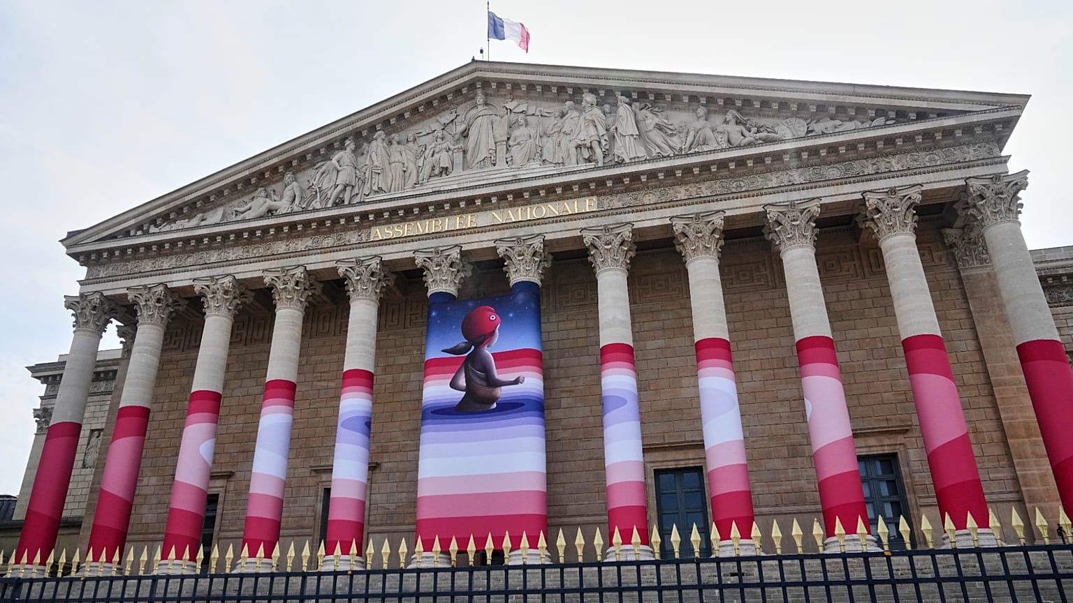 The French National Assembly is draped with the artwork "Marianne rêve" ("Marianne Dreams") by French street artist Seth, depicting Marianne the symbol of the French Republic