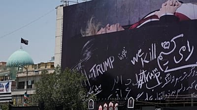 Рекламный щит с изображением Дональда Трампа, лежащего на гробе, с антитрампскими лозунгами на площади Исламской революции в Тегеране, Иран. 15 июля 2026 года.