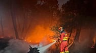 Dos bomberos se afanan en intentar apagar las llamas