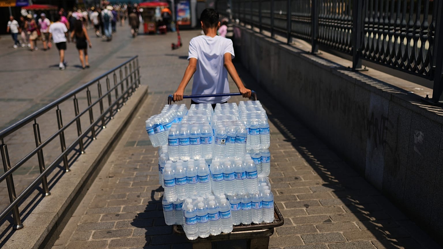 Mężczyzna rozdaje plastikowe butelki z wodą w upalny dzień w Stambule w Turcji, w sobotę 20 czerwca 2026 r. (AP Photo/Francisco Seco)